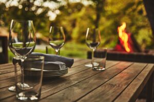 wine glasses sit atop a table while an elegant fire burns in the background