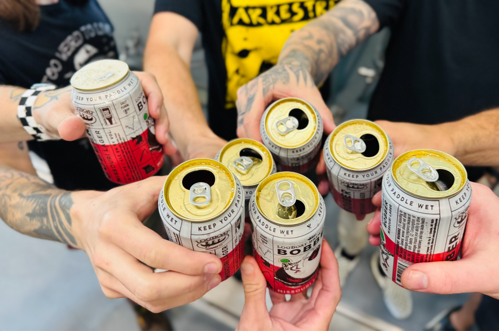 Logboat_BrewingCo_Hands_Cans Hands holding beer cans from Logboat Brewing Company.
